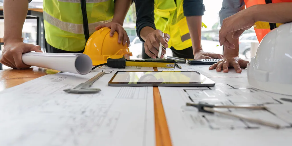 Equipo técnico revisando planos de ingeniería en obra